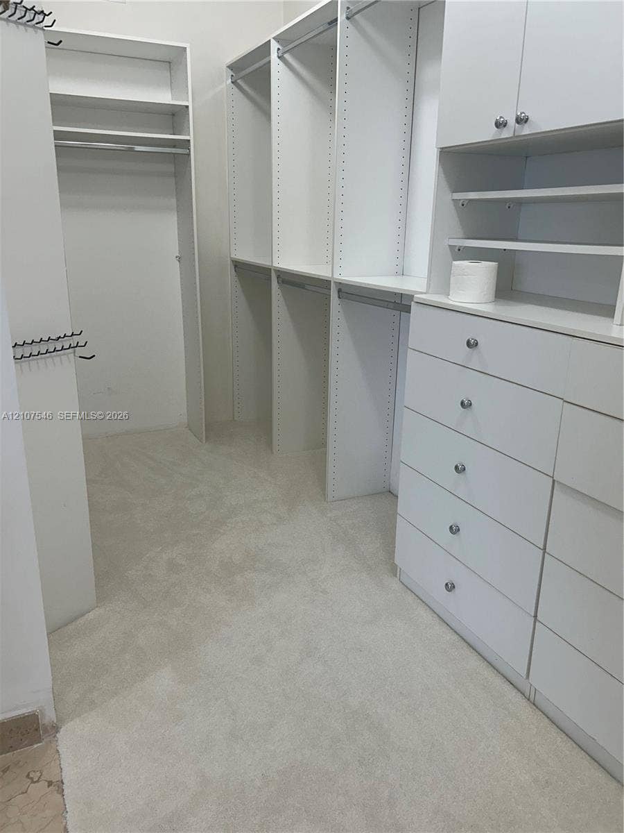 19333 Collins Avenue, #2007, Sunny Isles Beach, Sunny Isles Beach, FL 33160 Walk-in closet featuring white built-in cabinetry, floor-to-ceiling shelving, multiple drawer units, and hanging rods