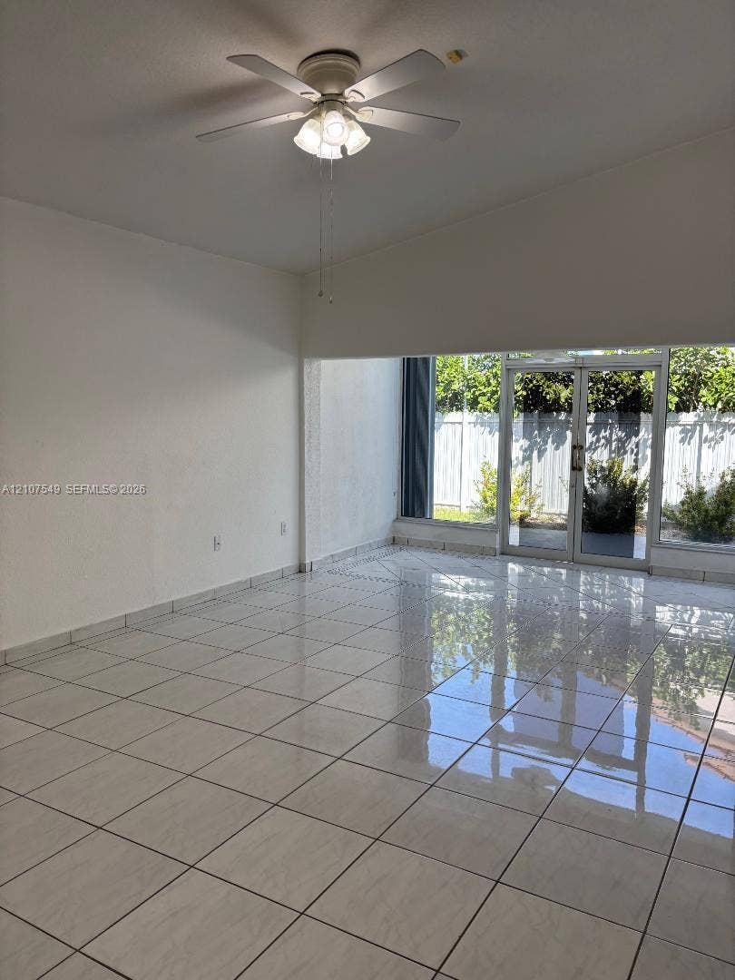 8995 NW 148th Street, #8995, Miami Lakes, Miami Lakes, FL 33018 Interior space featuring high-gloss tile flooring, ceiling fan with integrated lighting, and full-height glass double doors