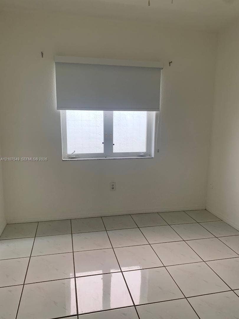 8995 NW 148th Street, #8995, Miami Lakes, Miami Lakes, FL 33018 Square tile flooring paired with a central window featuring a roller shade