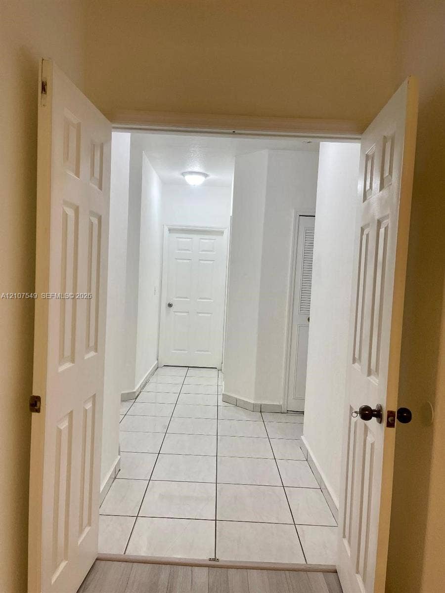 8995 NW 148th Street, #8995, Miami Lakes, Miami Lakes, FL 33018 Interior space featuring ceramic tile flooring, six-panel interior doors, and a louvered closet door
