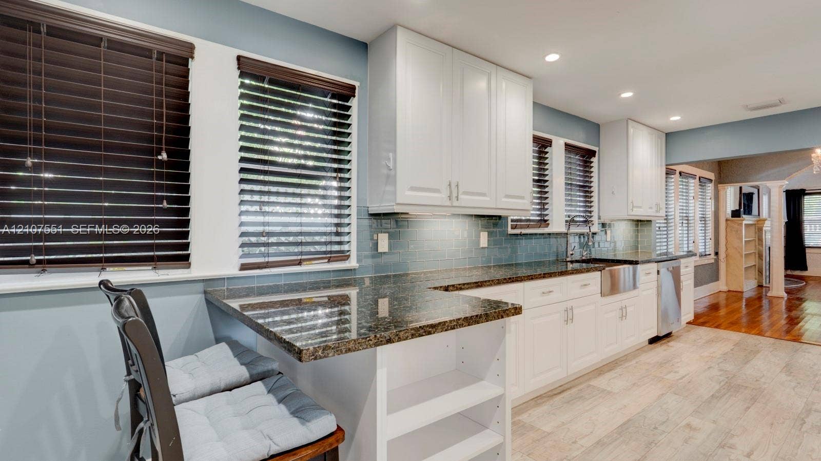 1676 SW 11th Street, Miami, Miami, FL 33135 Kitchen featuring white shaker cabinetry, stone countertops, farmhouse-style sink, subway tile backsplash, and wood-finish flooring