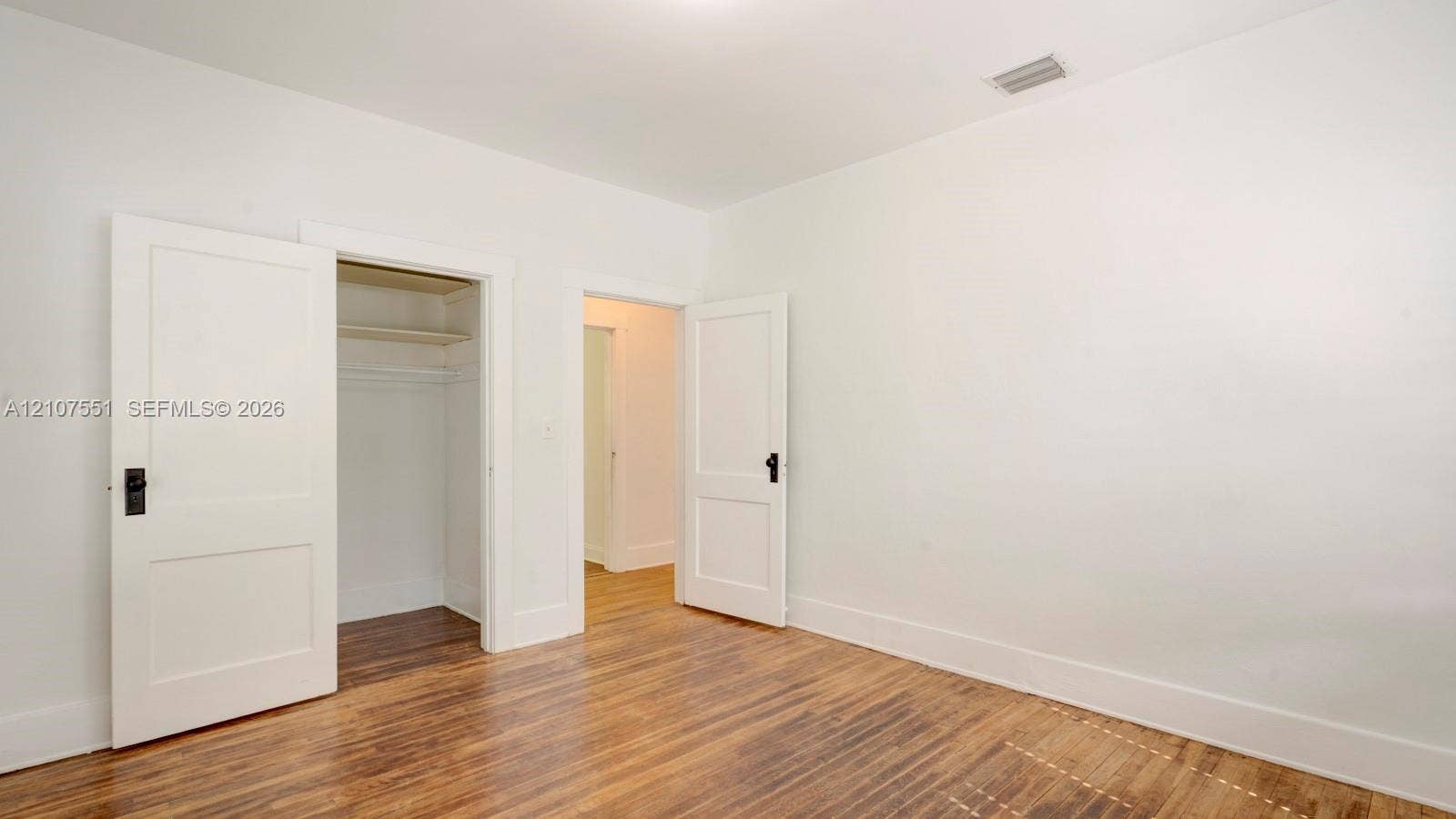 1676 SW 11th Street, Miami, Miami, FL 33135 Wood-finish flooring, two-panel interior doors with matte black hardware, and integrated closet shelving