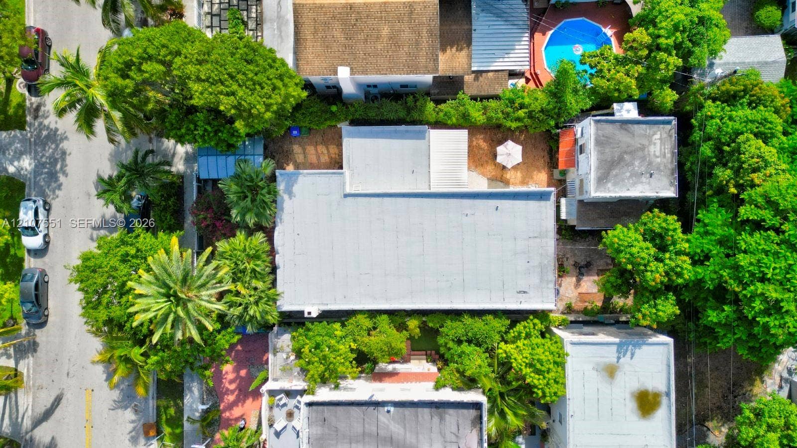 1676 SW 11th Street, Miami, Miami, FL 33135 Aerial perspective featuring a flat roofline, mature canopy trees, and paved hardscaping