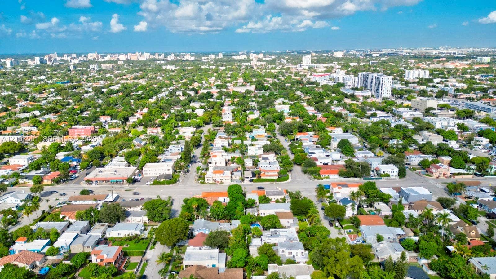 1676 SW 11th Street, Miami, Miami, FL 33135 Aerial perspective of a dense urban neighborhood featuring established tree canopy, grid-patterned streets, and proximity to a central metropolitan skyline