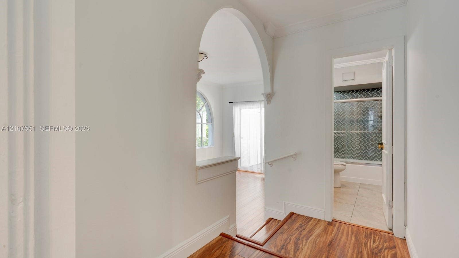 1676 SW 11th Street, Miami, Miami, FL 33135 Interior featuring a structural arched opening, wood-finish flooring, and crown molding