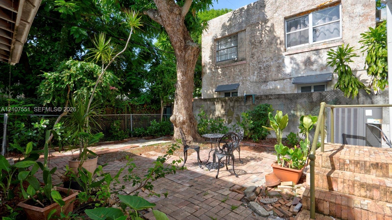 1676 SW 11th Street, Miami, Miami, FL 33135 Exterior courtyard featuring brick paving, mature trees, and masonry wall boundary