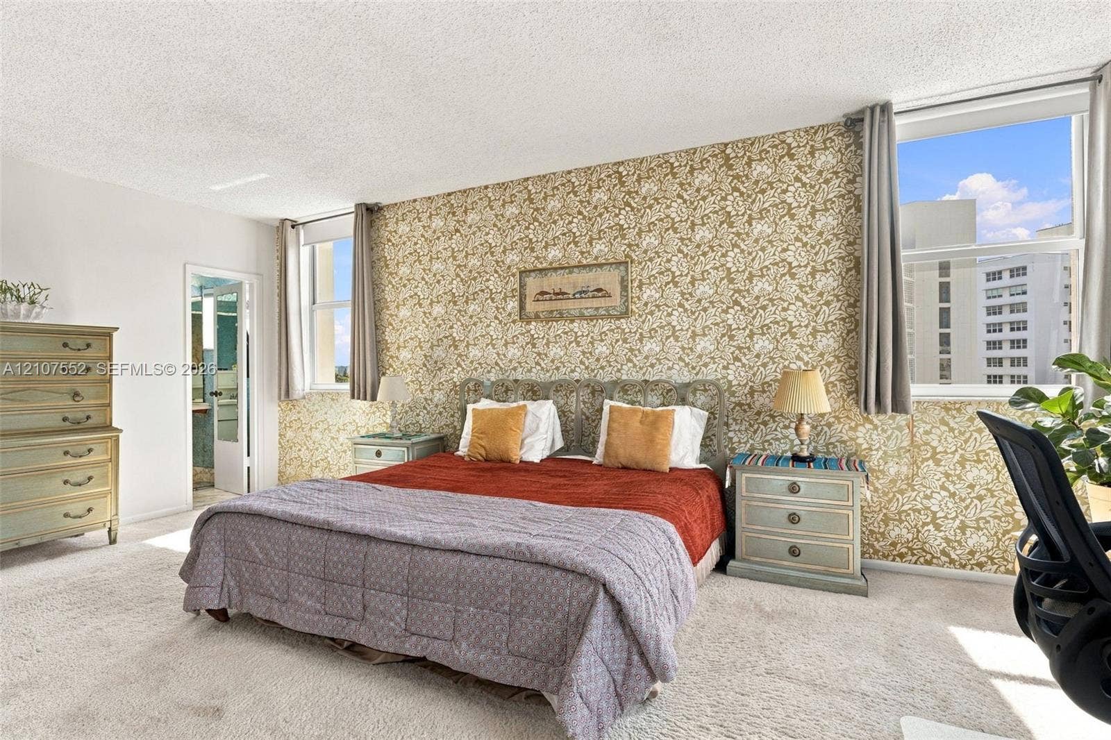 Spacious room featuring patterned wallpaper, carpeting, and oversized windows