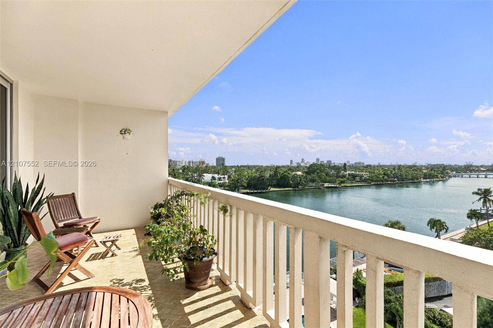 Covered private balcony featuring a protective balustrade and expansive water scenery