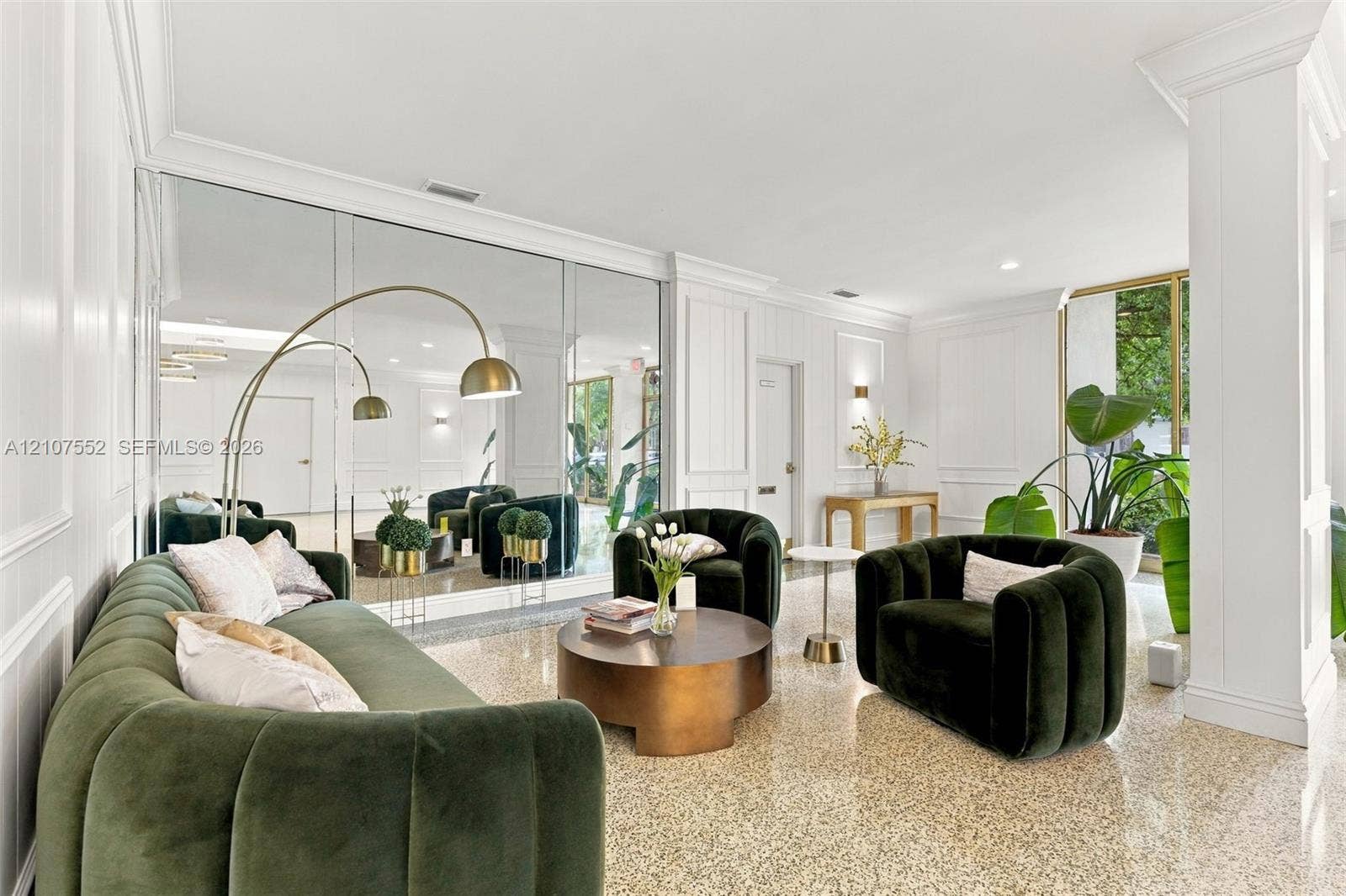 Polished terrazzo flooring, floor-to-ceiling mirror wall, architectural column, recessed lighting, and wall paneling