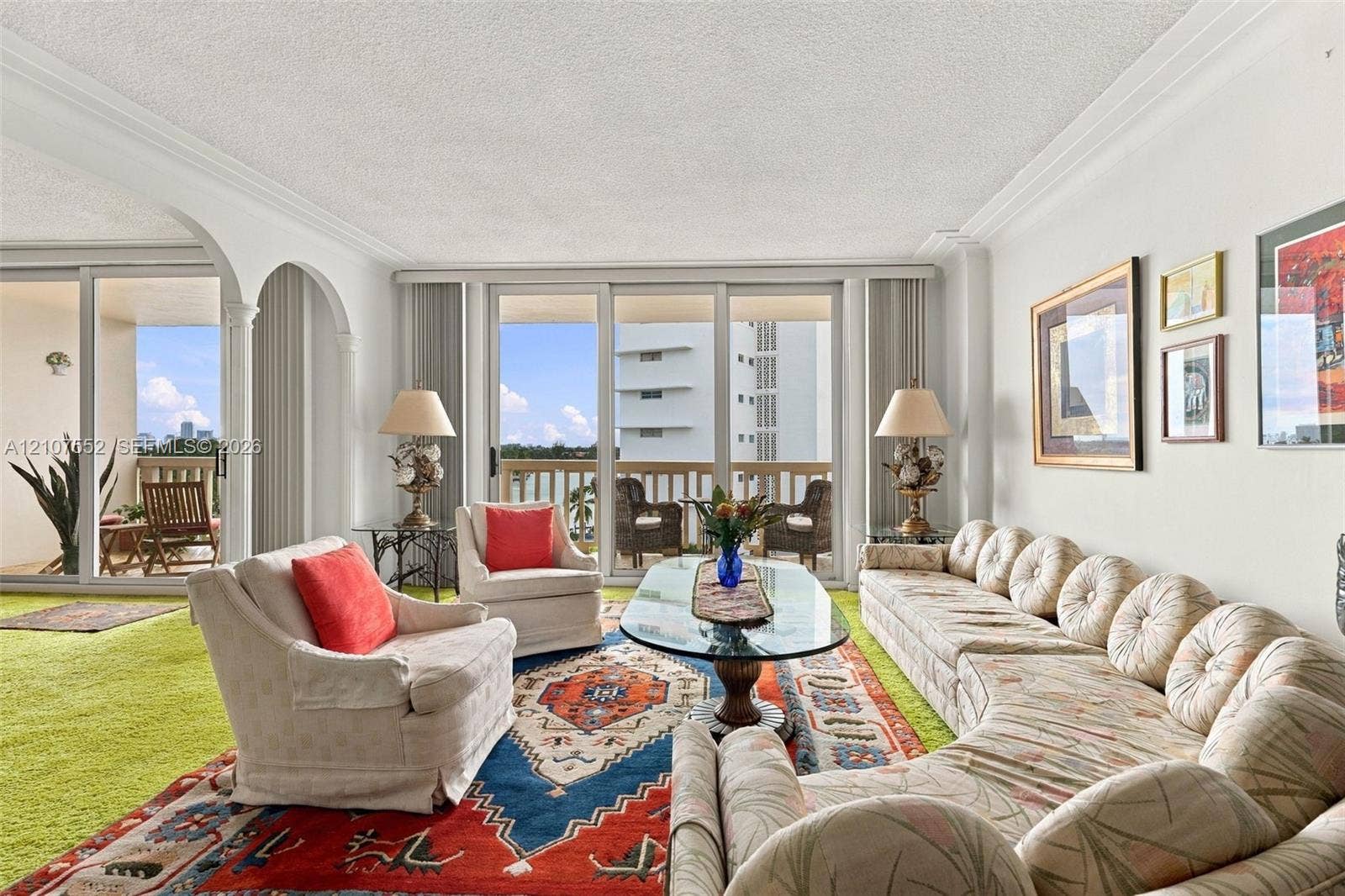 Living area featuring floor-to-ceiling glass sliding doors, arched architectural openings, and crown molding