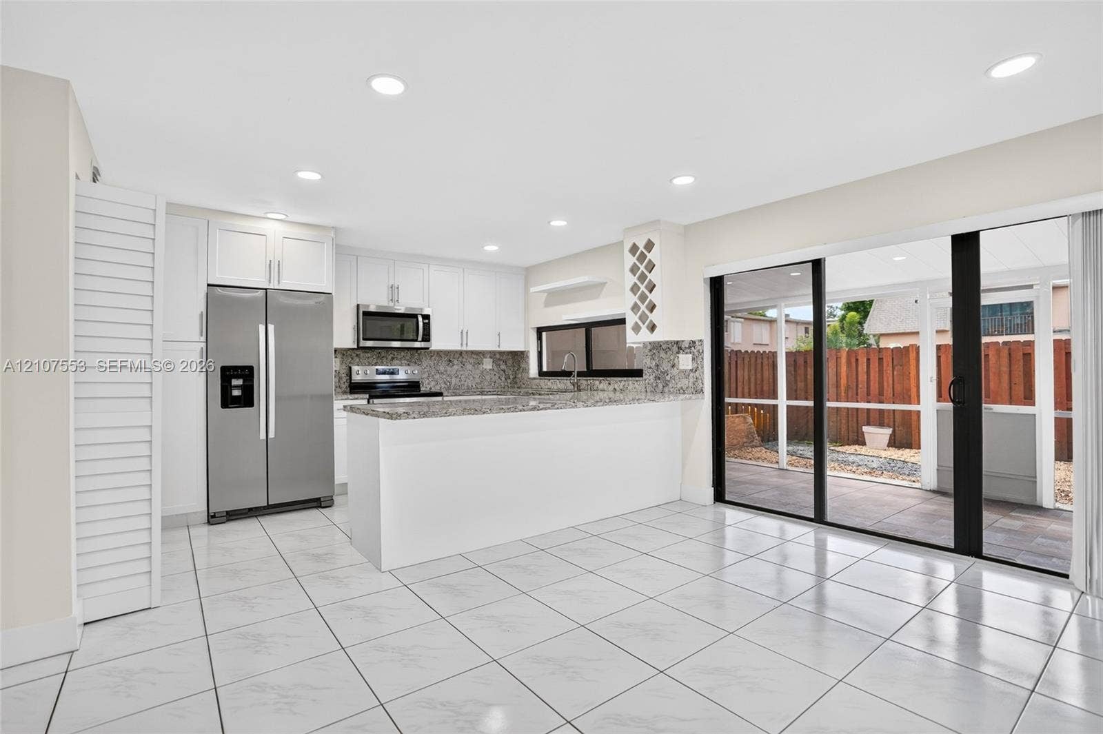 7336 SW 26th Court, #51, Davie, Davie, FL 33314 Kitchen featuring white cabinetry, stone-finish countertops, stainless steel appliances, built-in wine rack, and tile flooring throughout