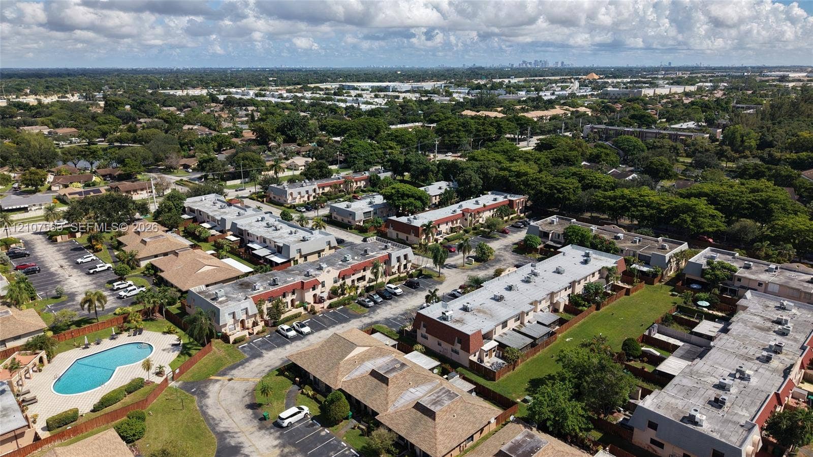 7336 SW 26th Court, #51, Davie, Davie, FL 33314 Aerial perspective featuring multi-story residential structures, paved surface parking lots, and a communal swimming pool set within landscaped grounds