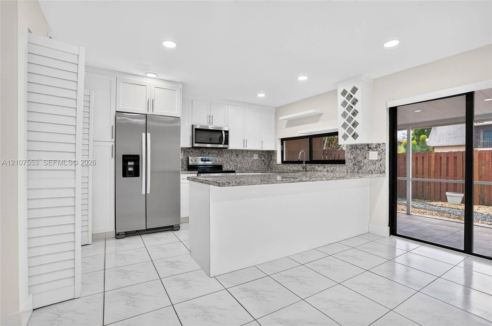 7336 SW 26th Court, #51, Davie, Davie, FL 33314 Kitchen featuring white cabinetry, stone countertops, stainless steel appliances, a built-in wine rack, and tile flooring