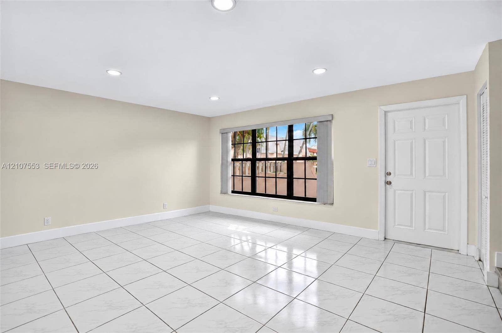 7336 SW 26th Court, #51, Davie, Davie, FL 33314 Neutral-toned interior featuring large-format tile flooring, recessed ceiling lighting, a six-panel exterior door, and a multi-pane window with a black frame