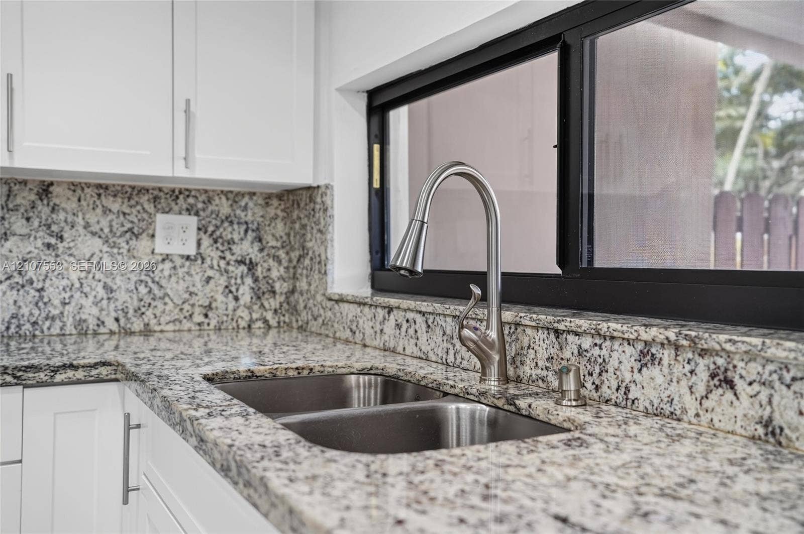 7336 SW 26th Court, #51, Davie, Davie, FL 33314 Stone-surface countertops with matching backsplash, white shaker-style cabinetry, stainless steel double-basin undermount sink, and high-arc pull-down faucet featuring a brushed metallic finish