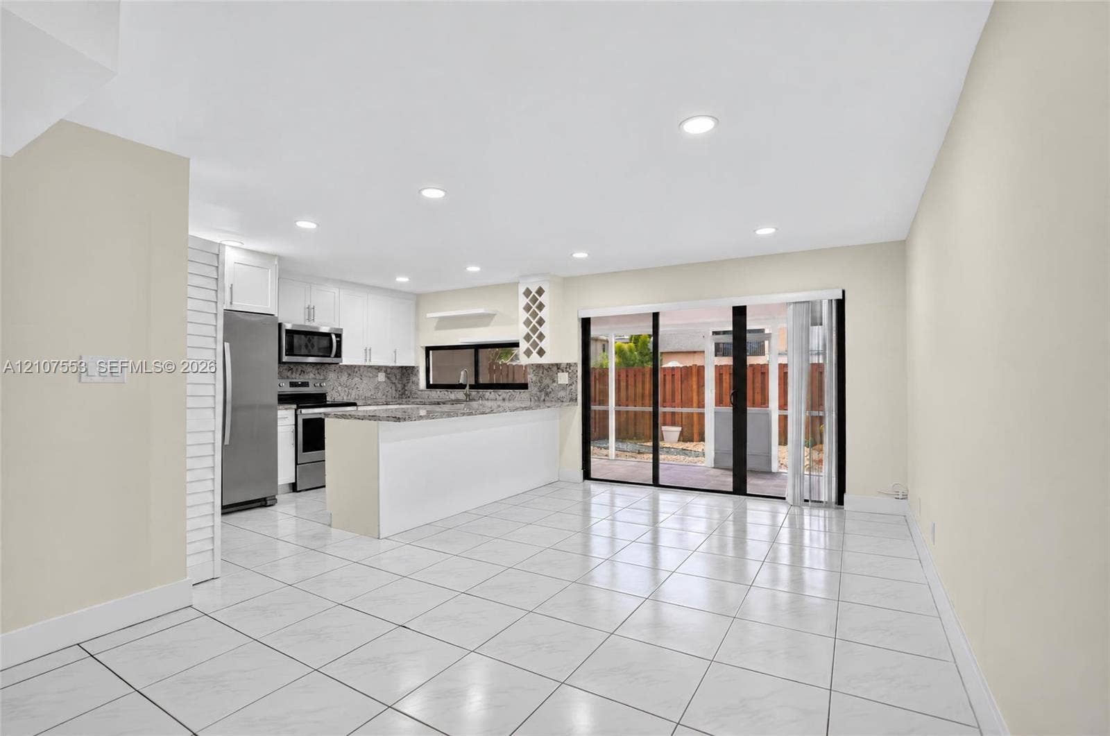 7336 SW 26th Court, #51, Davie, Davie, FL 33314 Open-concept kitchen featuring a breakfast bar, stone-finish countertops, stainless steel appliances, recessed lighting, and tile flooring