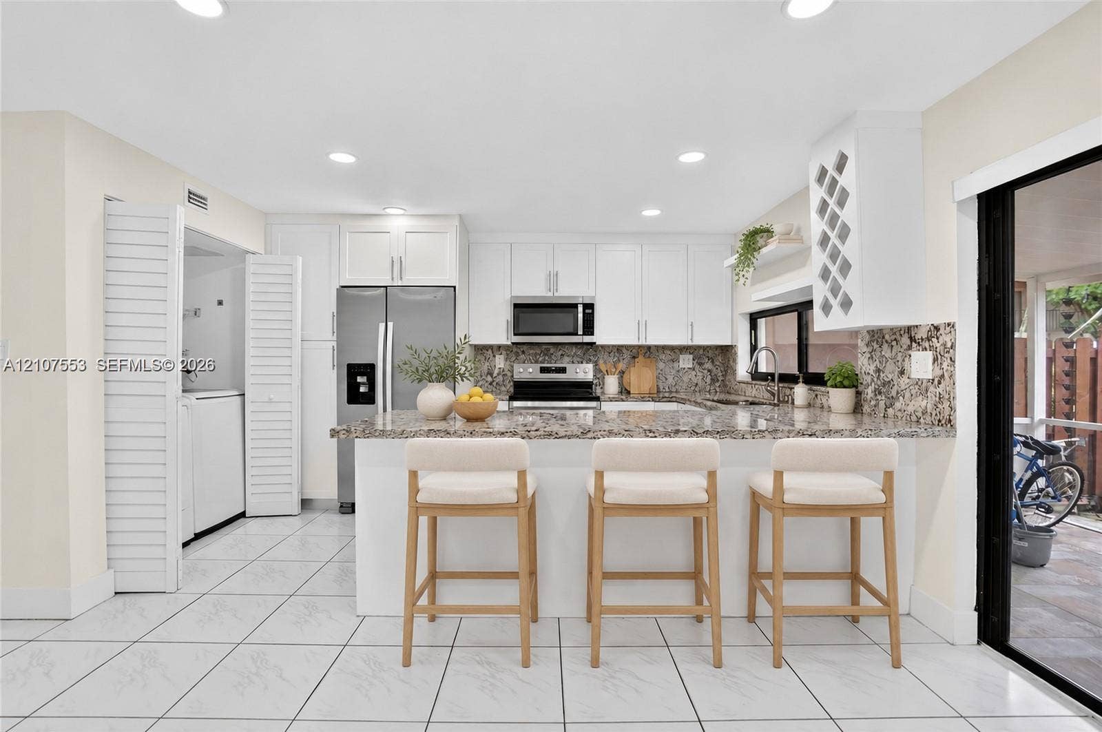 7336 SW 26th Court, #51, Davie, Davie, FL 33314 Kitchen featuring white shaker-style cabinetry, stone-finish countertops, stainless steel appliances, a built-in wine rack, and tile flooring