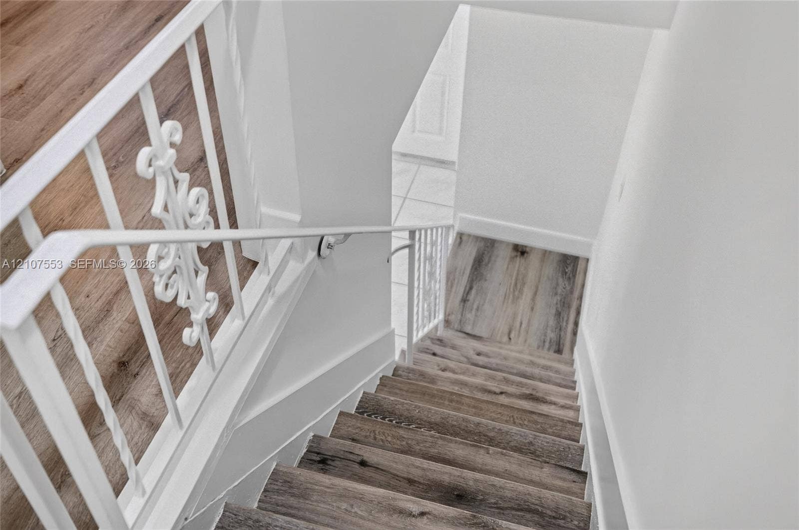 7336 SW 26th Court, #51, Davie, Davie, FL 33314 Staircase featuring wood-finish flooring, white metal balusters with decorative scrollwork, and a matching handrail