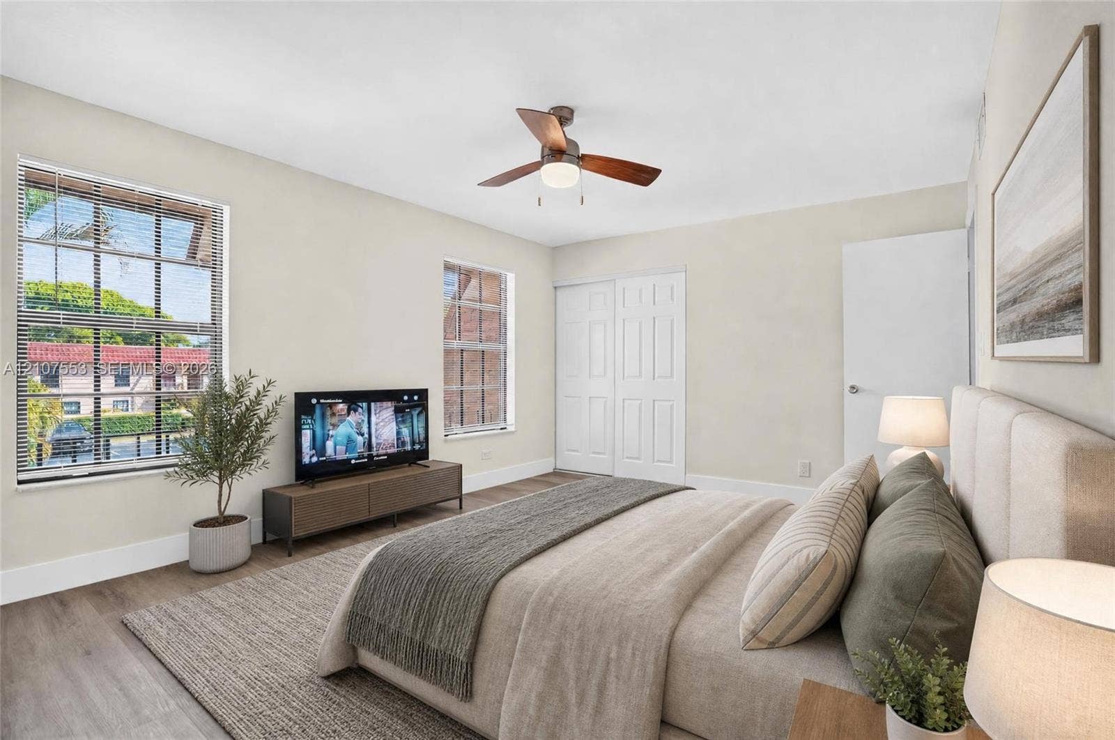 7336 SW 26th Court, #51, Davie, Davie, FL 33314 Bedroom featuring wood-finish flooring, dual windows, ceiling fan with integrated lighting, and a closet with paneled sliding doors
