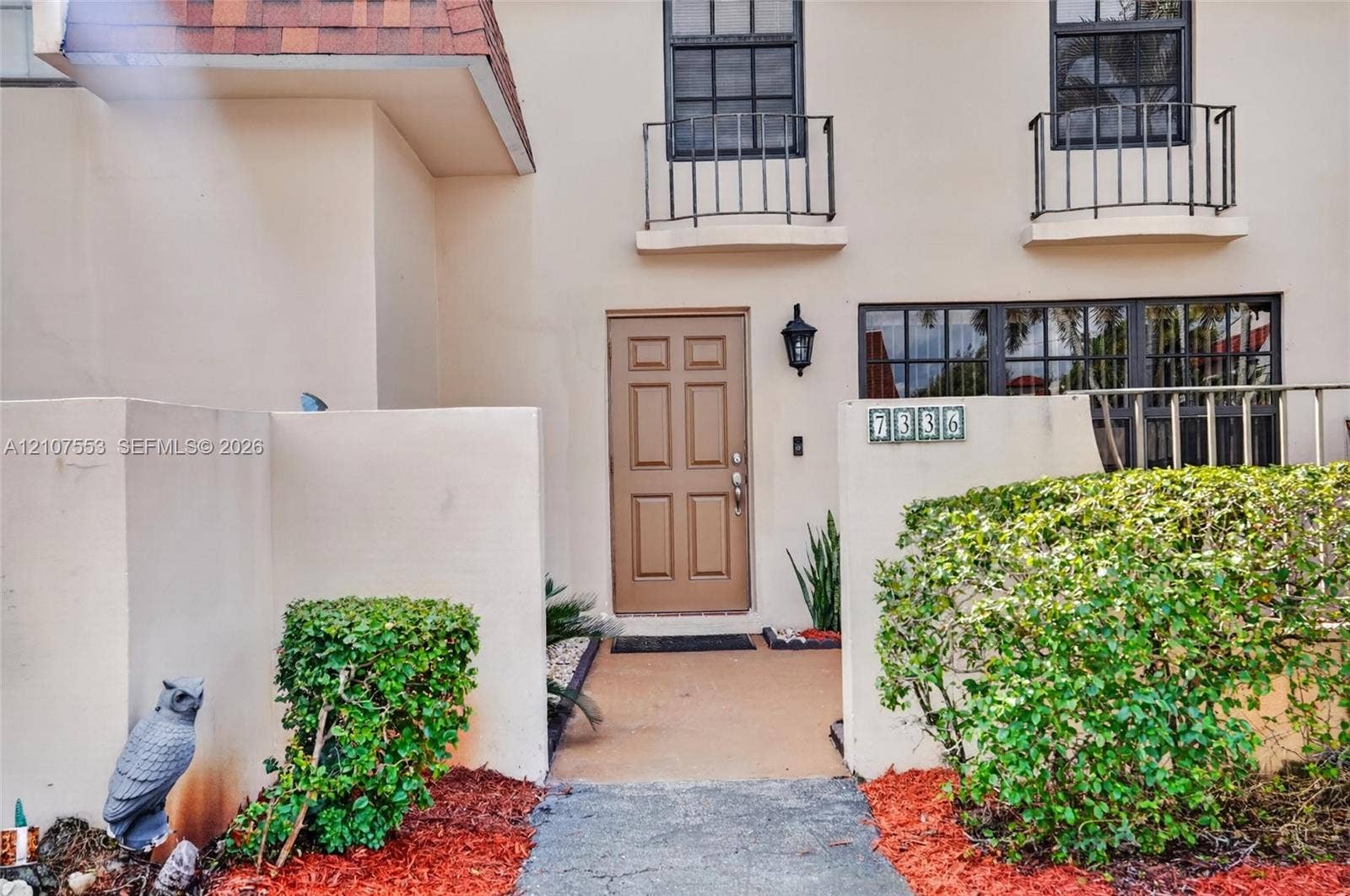 7336 SW 26th Court, #51, Davie, Davie, FL 33314 Stucco exterior featuring dual Juliet balconies, six-panel entry door, and a private enclosed front courtyard