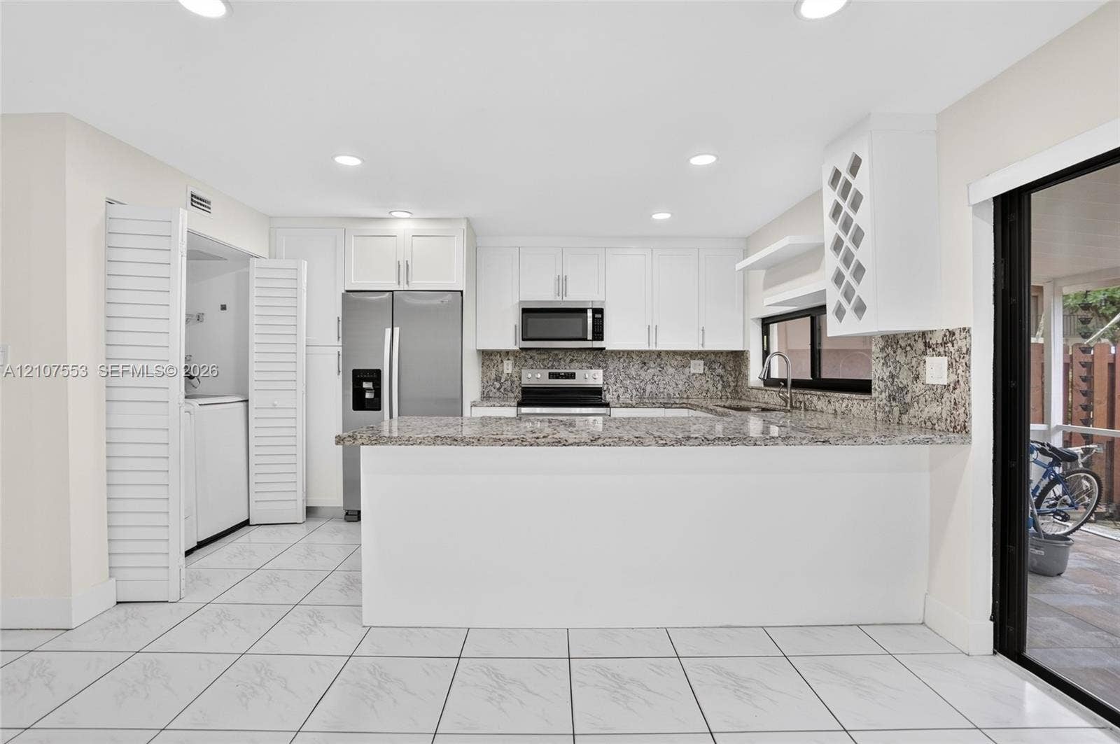 7336 SW 26th Court, #51, Davie, Davie, FL 33314 Kitchen featuring white cabinetry, stone countertops, stainless steel appliances, built-in wine storage, and ceramic tile flooring