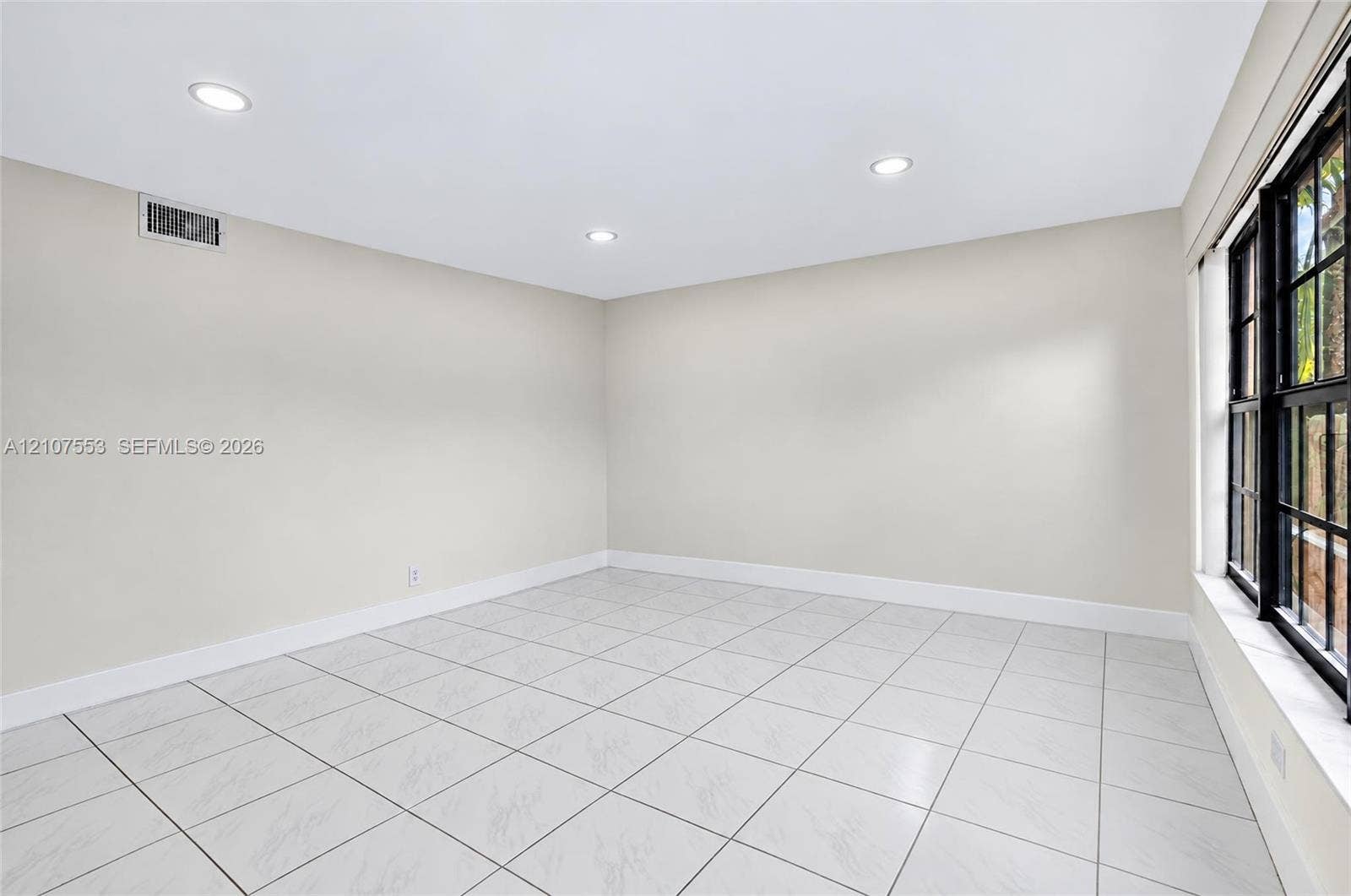 7336 SW 26th Court, #51, Davie, Davie, FL 33314 Neutral-toned interior space featuring light-colored tile flooring, recessed lighting, and a multi-pane window with a black frame