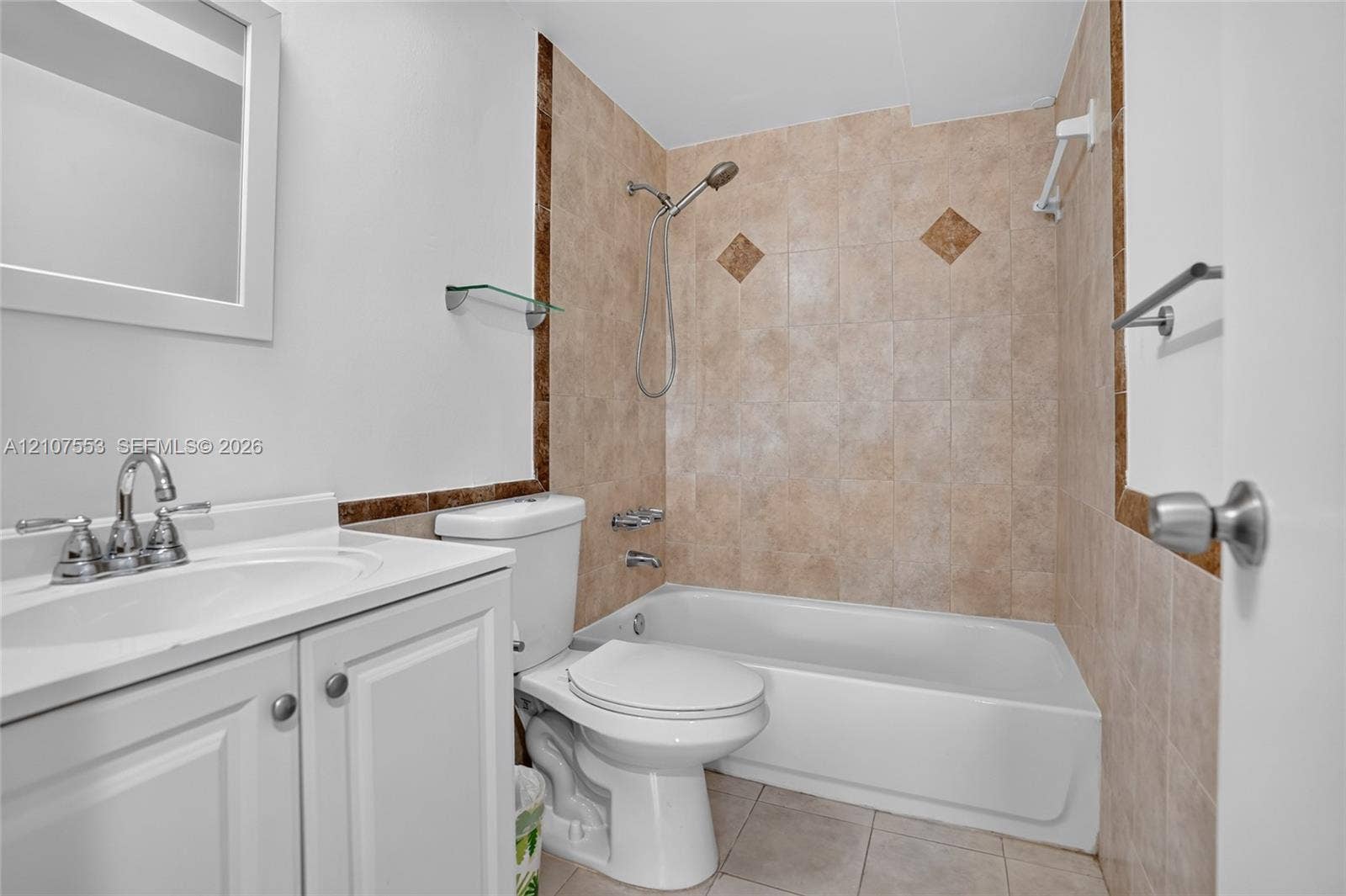7336 SW 26th Court, #51, Davie, Davie, FL 33314 Bathroom featuring a white vanity cabinet, ceramic tile tub surround with decorative accents, wall-mounted mirror, and a combination bathtub and shower