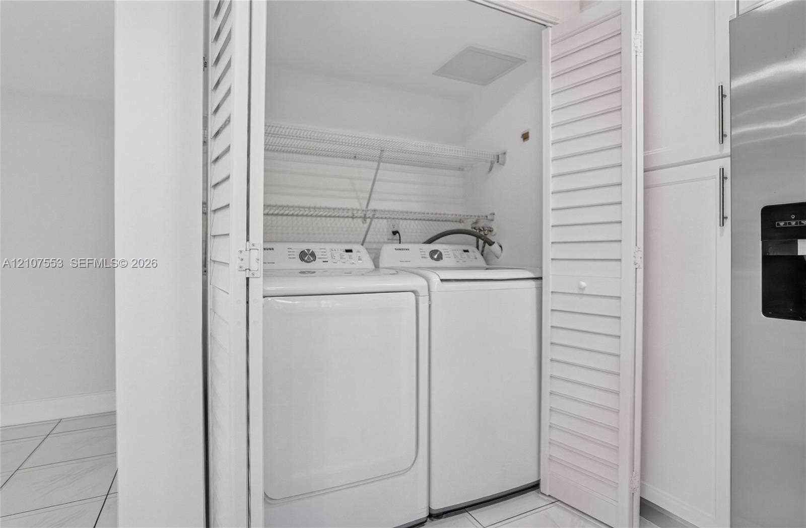 7336 SW 26th Court, #51, Davie, Davie, FL 33314 Laundry closet featuring white louvered doors, wire shelving, and tiled flooring