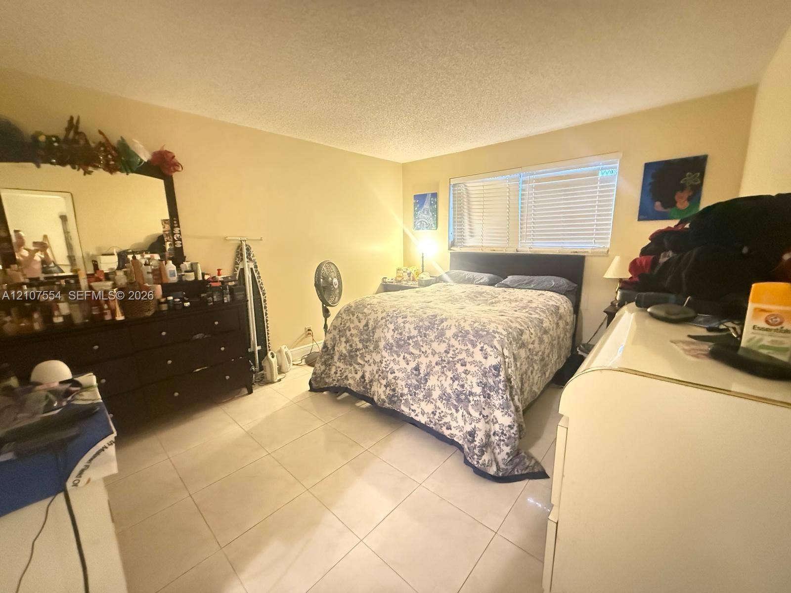 Interior room featuring light-toned tile flooring and horizontal window blinds