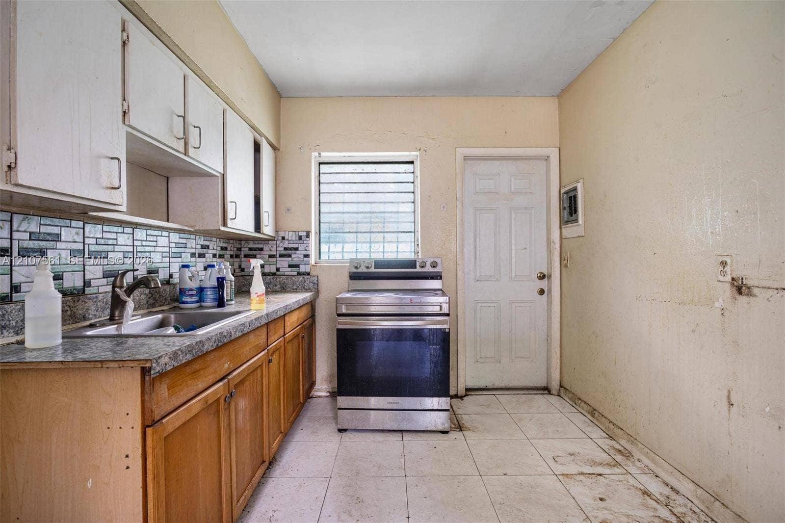 50 NW 69th Street, Miami, FL 33150 Kitchen featuring natural wood cabinetry, stone-finish countertops, tile backsplash, stainless steel oven, and tile flooring