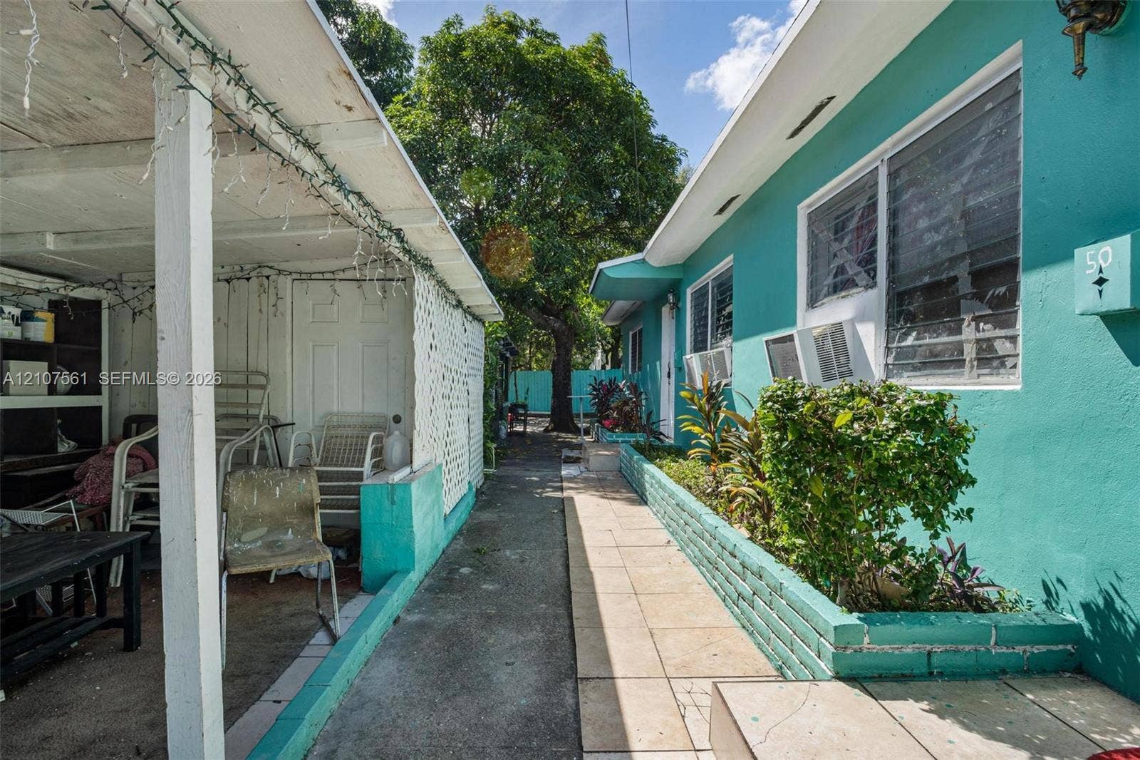50 NW 69th Street, Miami, FL 33150 Exterior space featuring a covered patio, concrete walkway, and a raised masonry planter box