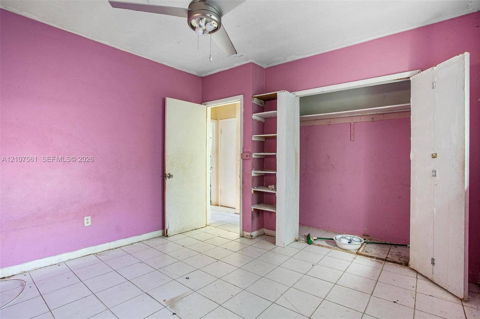50 NW 69th Street, Miami, FL 33150 Room featuring white tile flooring, ceiling fan, and built-in wall shelving