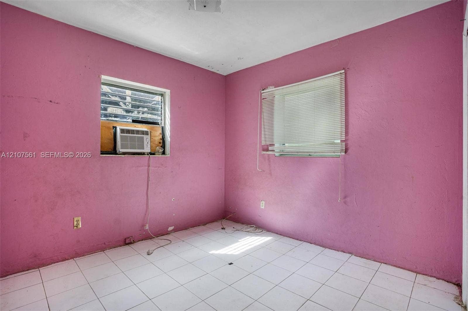 50 NW 69th Street, Miami, FL 33150 Room featuring white tile flooring and two windows with horizontal blinds