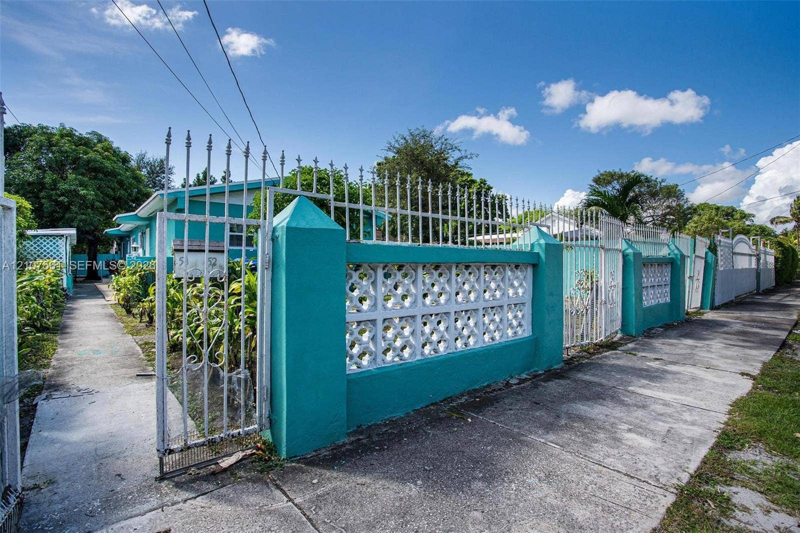 50 NW 69th Street, Miami, FL 33150 Exterior perimeter featuring decorative concrete screen walling, metal fencing, and integrated masonry pillars