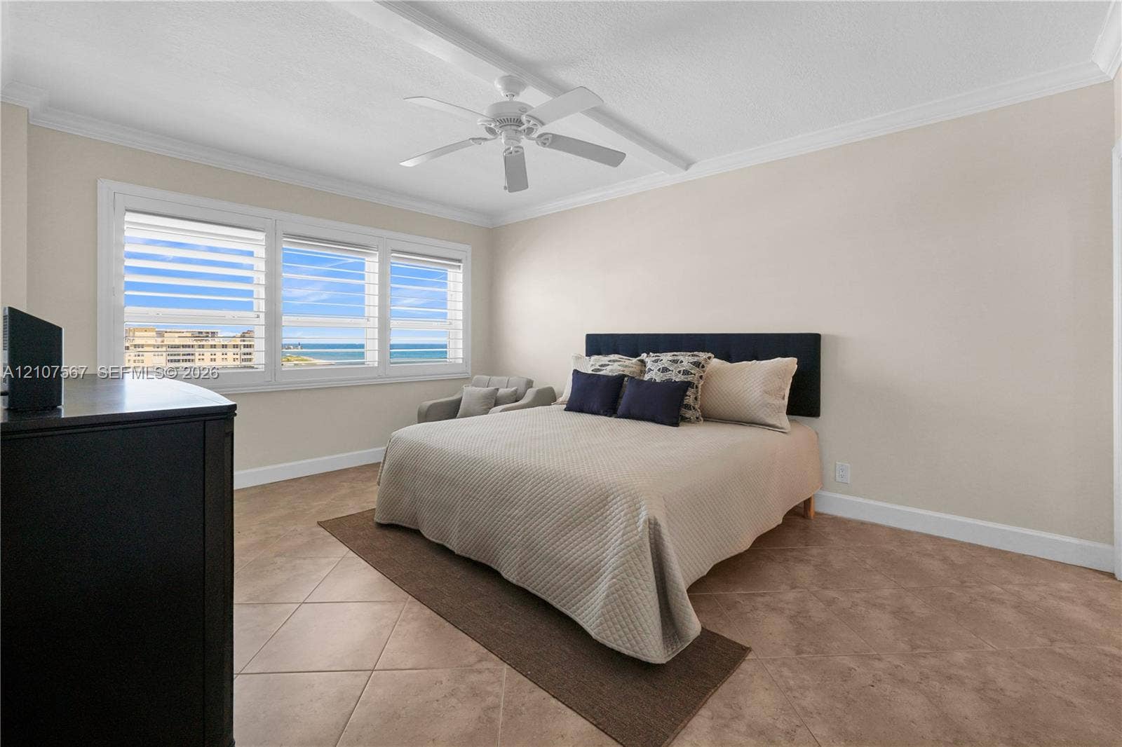 Tile flooring, crown molding, ceiling fan, and multi-pane windows with ocean exposure