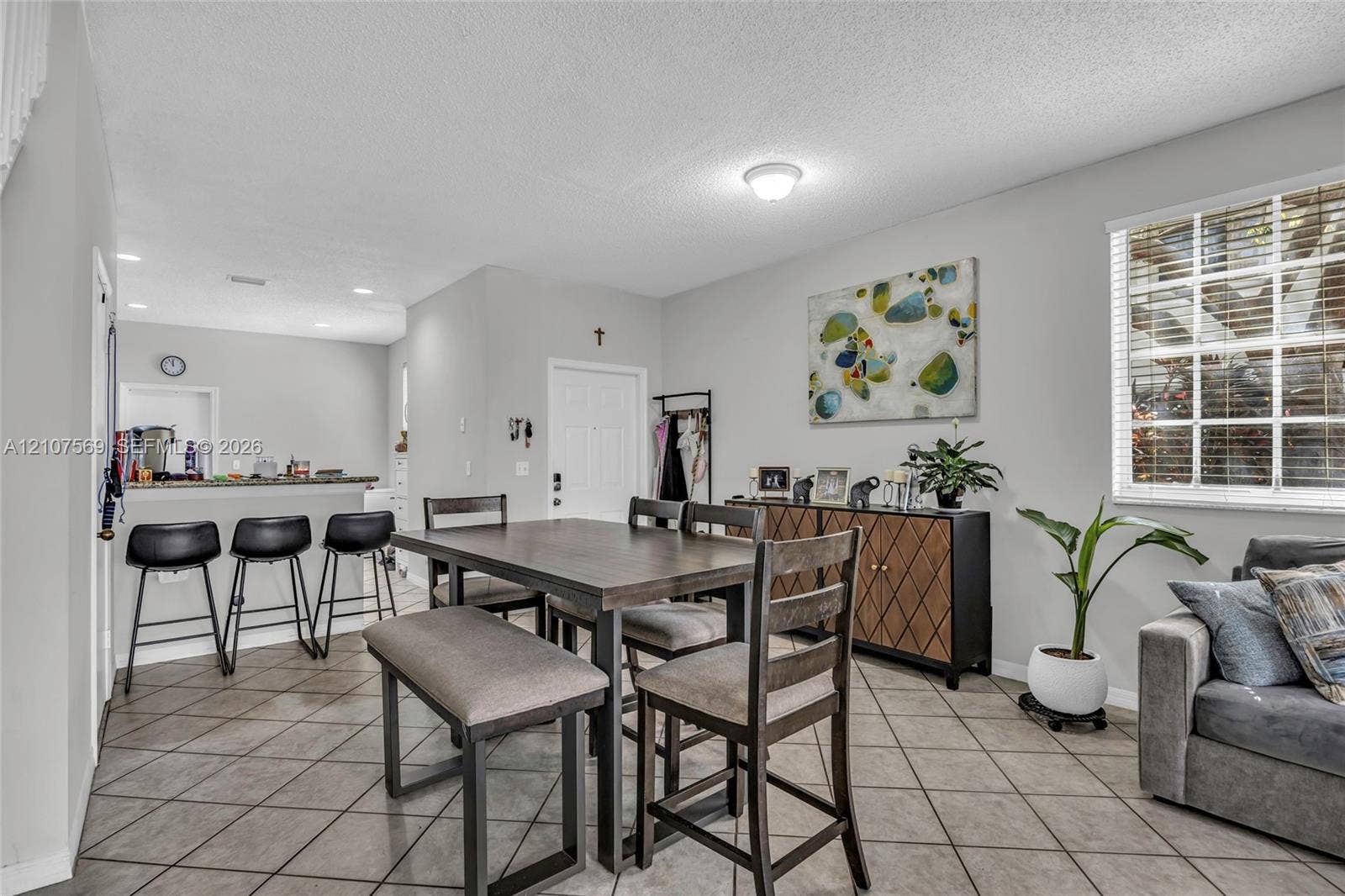 3765 San Simeon Circle, #3765, Weston, Weston, FL 33331 Open-concept interior featuring large-format diagonal tile flooring, a breakfast bar with stone-surface countertop, and multi-pane window