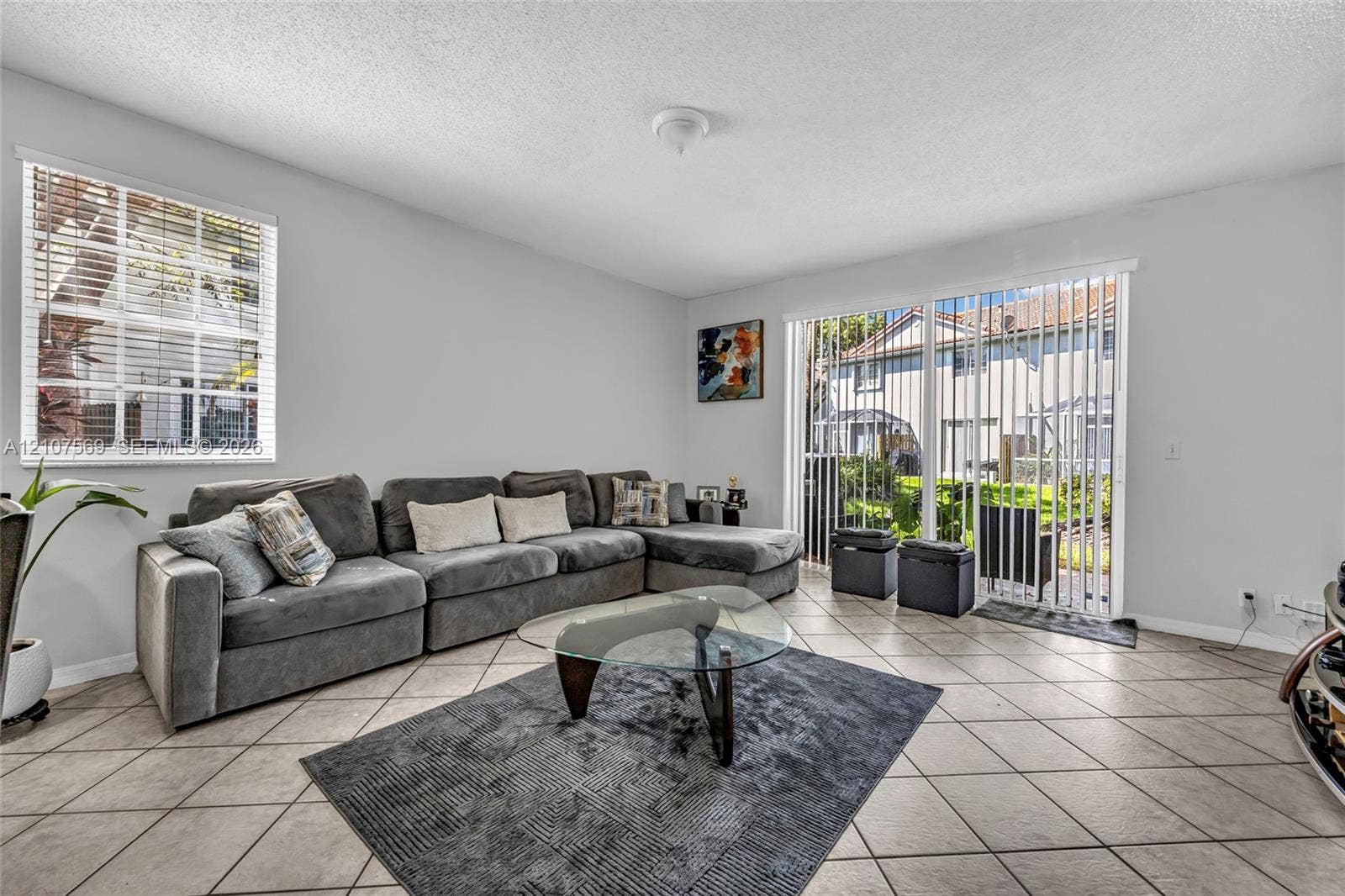 3765 San Simeon Circle, #3765, Weston, Weston, FL 33331 Living space featuring light-toned ceramic tile flooring, a multi-pane window, and a sliding glass door providing external access