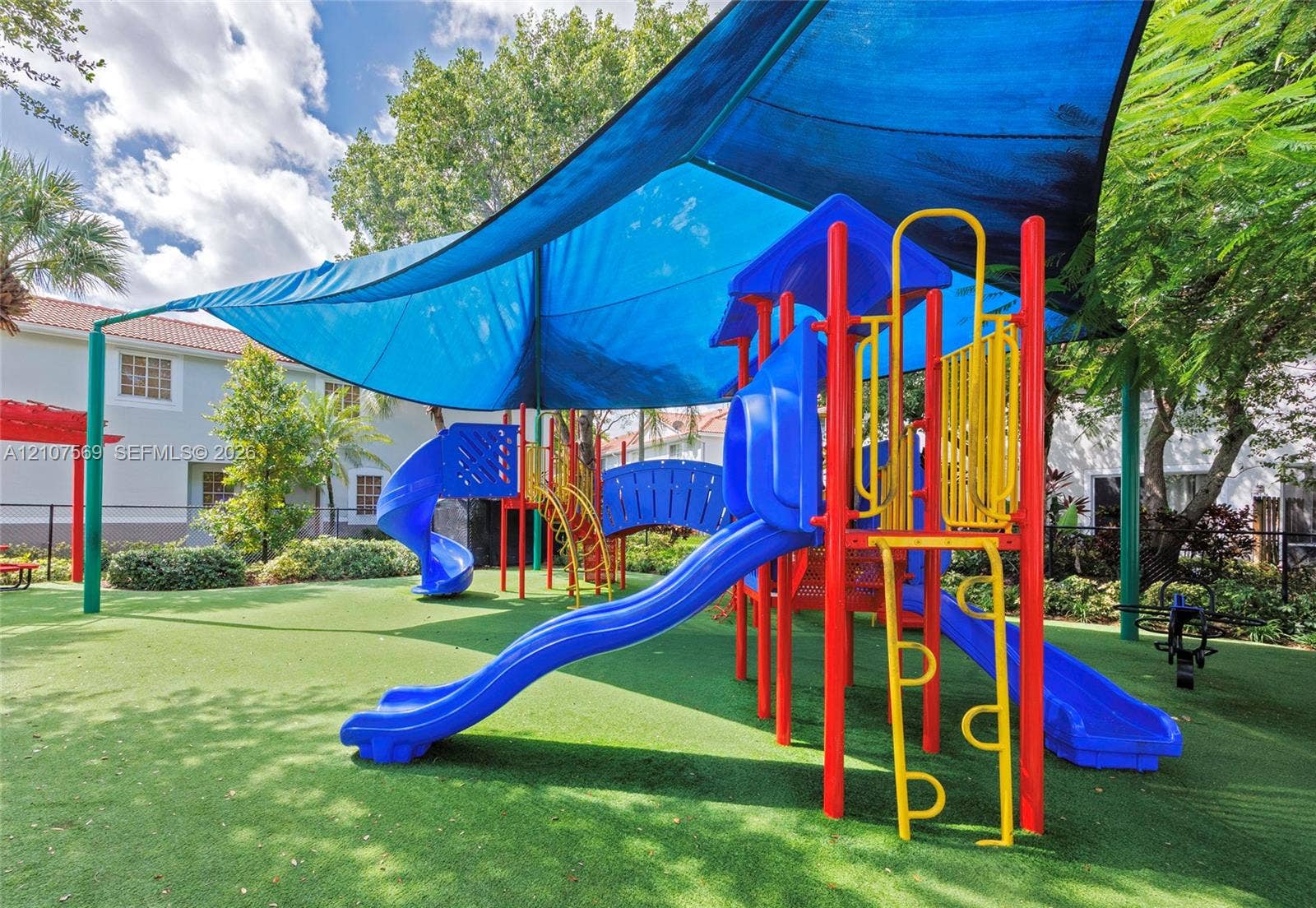 3765 San Simeon Circle, #3765, Weston, Weston, FL 33331 Outdoor recreational area featuring a multi-level playground structure, synthetic turf ground cover, and a large overhead shade canopy