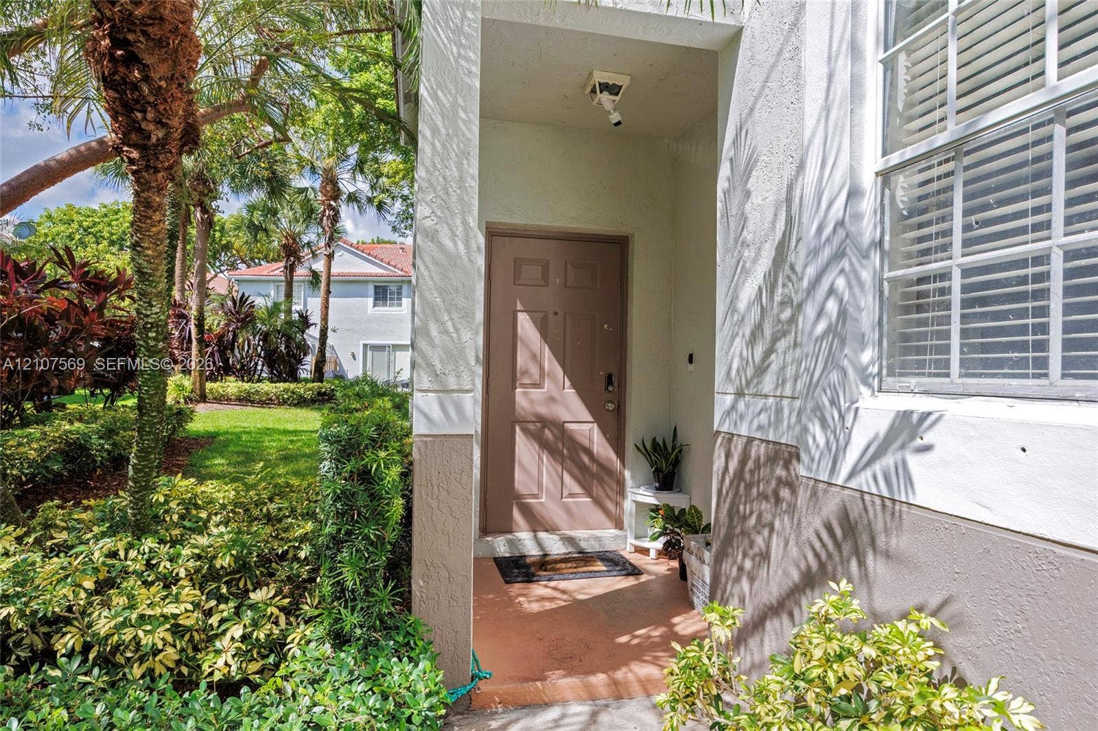 3765 San Simeon Circle, #3765, Weston, Weston, FL 33331 Covered entryway featuring a solid-panel entry door, exterior recessed lighting, and a multi-pane window with integrated blinds