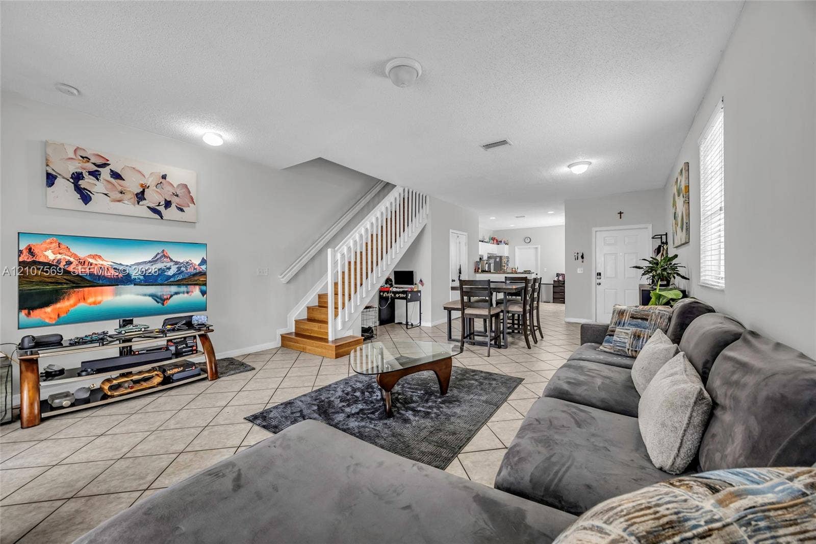 3765 San Simeon Circle, #3765, Weston, Weston, FL 33331 Open concept interior featuring tile flooring, a central staircase with white wood balusters and wood-finish treads, and recessed lighting