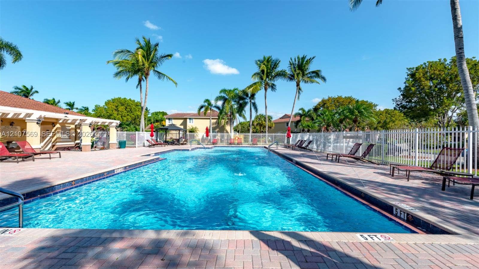 3765 San Simeon Circle, #3765, Weston, Weston, FL 33331 In-ground swimming pool featuring a brick-paver deck, pergola-covered patio, and metal perimeter fencing