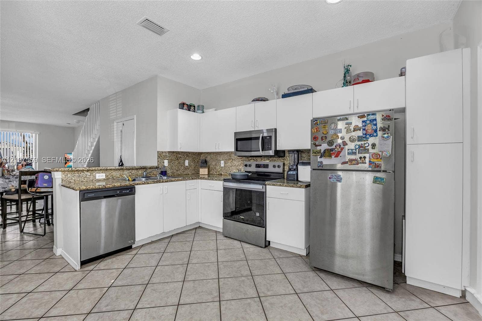3765 San Simeon Circle, #3765, Weston, Weston, FL 33331 Kitchen featuring white shaker-style cabinetry, stone countertops, stainless steel appliances, and ceramic tile flooring
