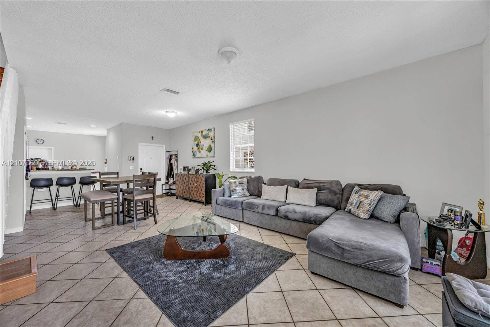 3765 San Simeon Circle, #3765, Weston, Weston, FL 33331 Open-concept interior featuring neutral wall tones, large-format tile flooring laid on the diagonal, and a breakfast bar