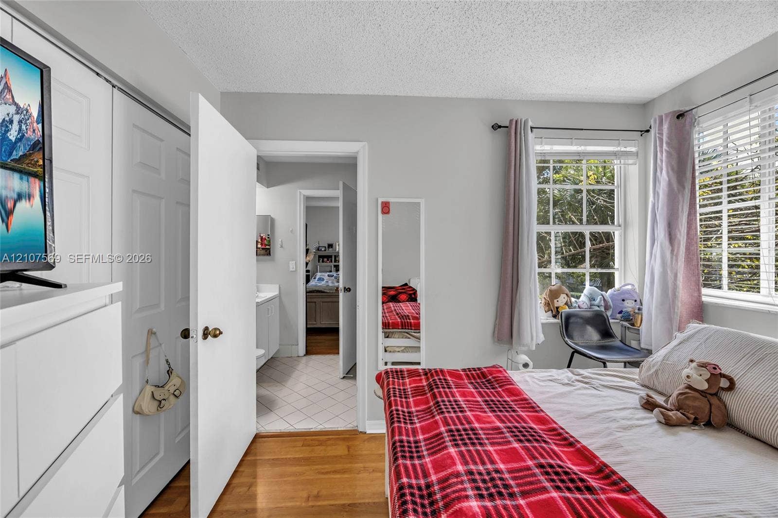 3765 San Simeon Circle, #3765, Weston, Weston, FL 33331 Bedroom featuring wood-finish flooring, multi-panel sliding closet doors, and a multi-pane window with horizontal blinds