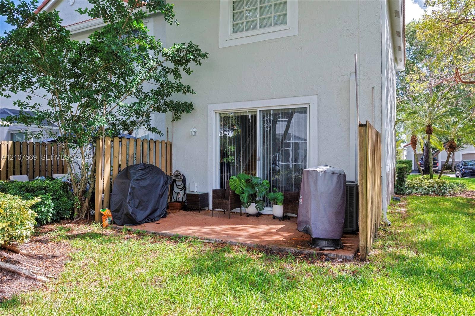 3765 San Simeon Circle, #3765, Weston, Weston, FL 33331 Stucco exterior featuring a sliding glass door, paved patio, and wood privacy fencing