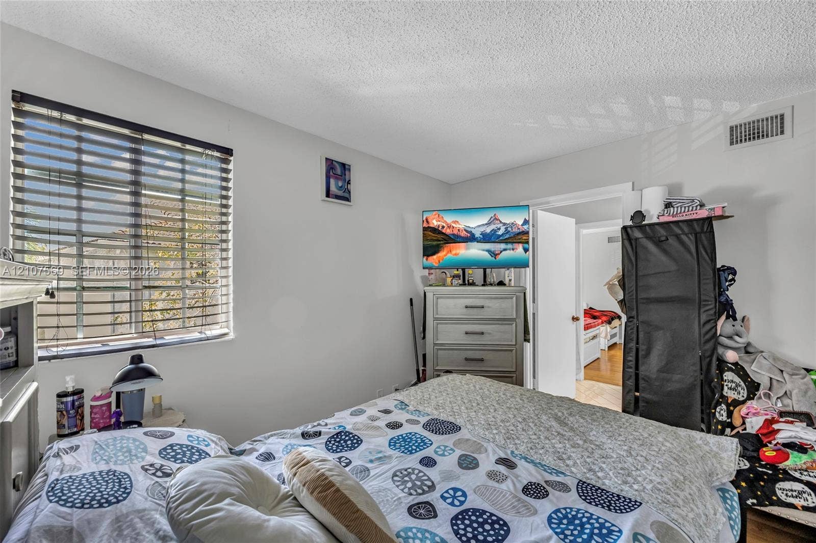 3765 San Simeon Circle, #3765, Weston, Weston, FL 33331 Bedroom featuring horizontal window blinds, textured ceiling finish, and interior door with brushed metal hardware