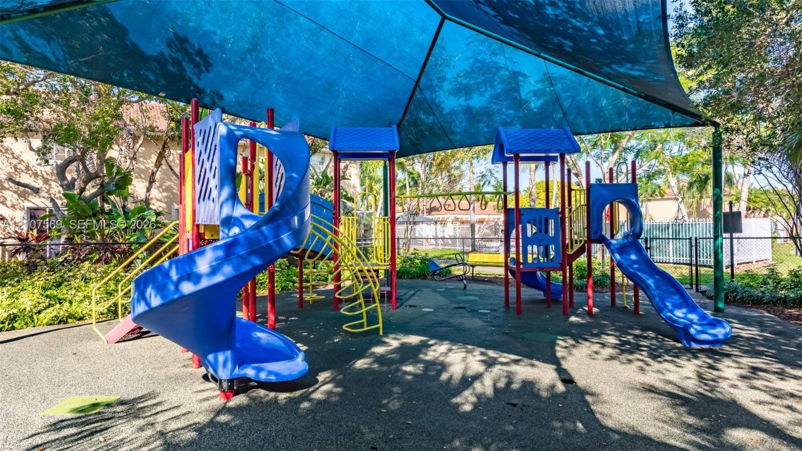 3765 San Simeon Circle, #3765, Weston, Weston, FL 33331 Recreational area featuring a multi-structure play system, dual slides, monkey bars, and a large overhead shade canopy