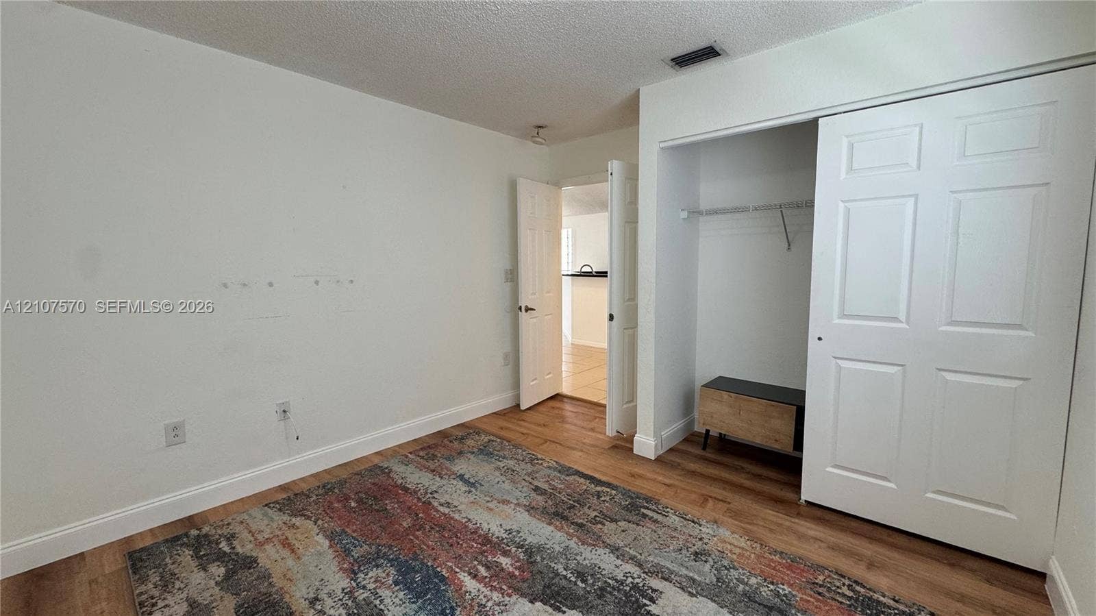 Wood-finish flooring, six-panel interior doors, and a double-door closet with built-in shelving