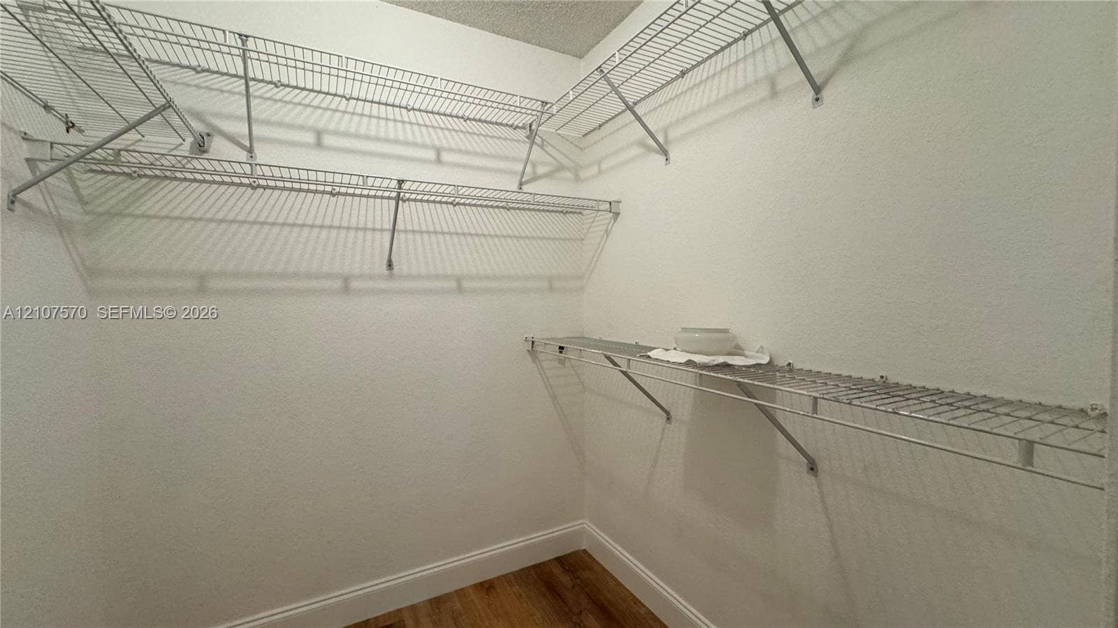 Storage area featuring wood-finish flooring and multi-level white wire shelving