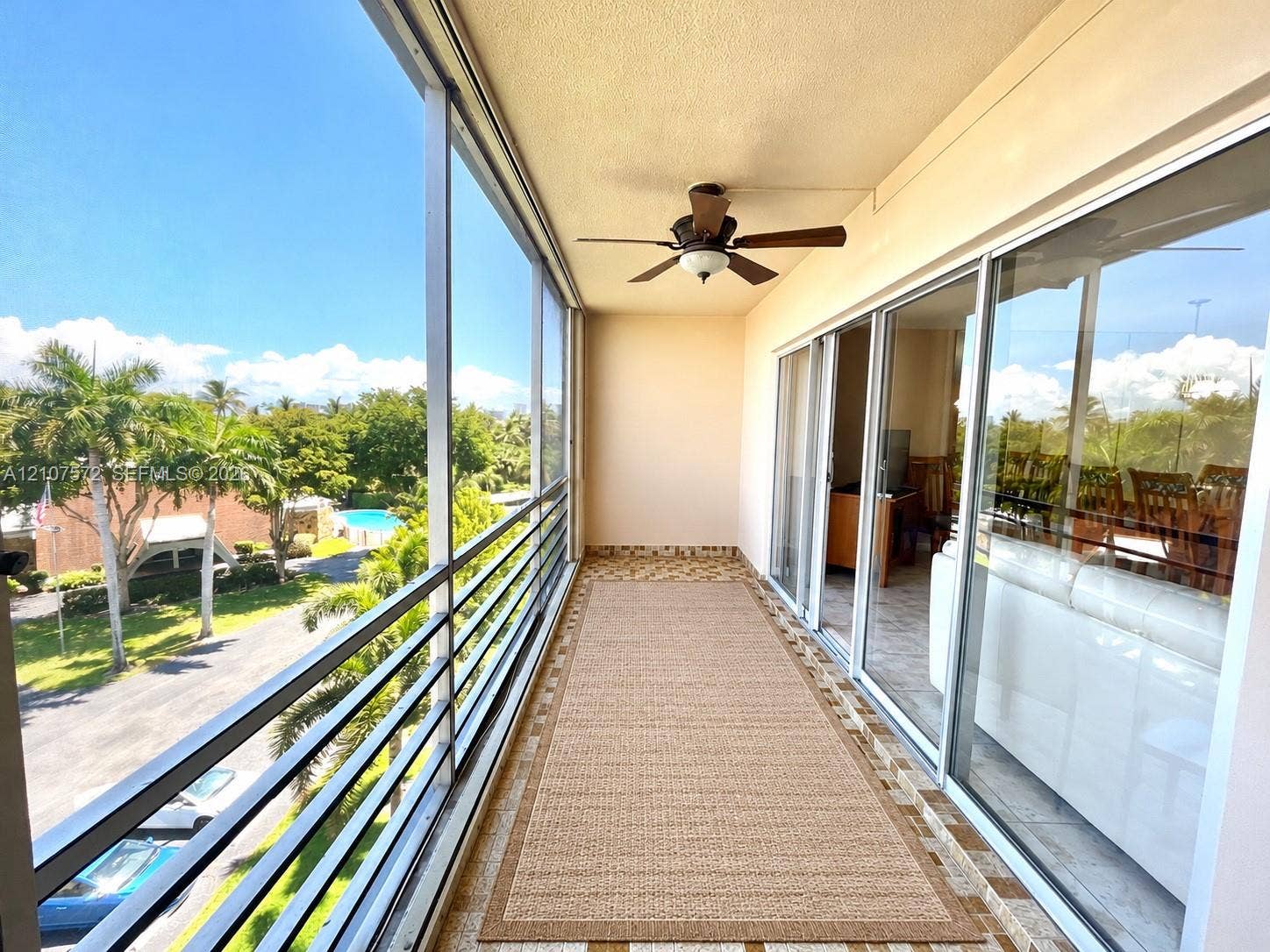1425 Atlantic Shores Boulevard, #501, Hallandale Beach, FL 33009 Screened-in balcony featuring metal railing, tiled flooring, and a ceiling fan